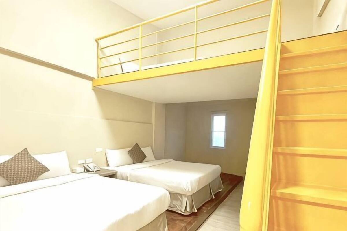 Ein Zimmer mit zwei Betten, einem Etagenbett, einem Fenster und einer Tür.