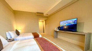 Ein Hotelzimmer mit zwei Betten, einem Fernseher auf einem Holzständer und Blick auf einen See.