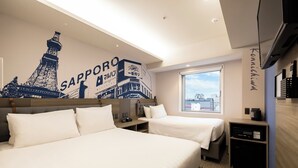 Ein Hotelzimmer mit zwei Betten, einem großen Fenster, einem Stadtbild-Wandgemälde und einer Minibar.