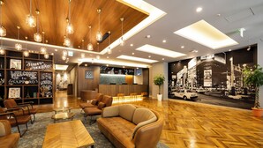 Eine moderne Lobby mit Holzboden, Ledersofas und einer Rezeption.