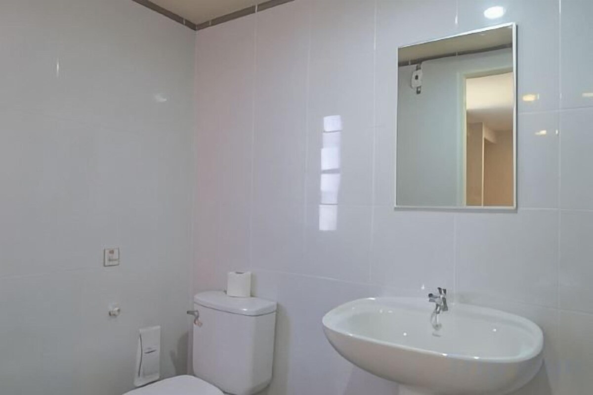 Un baño con inodoro, lavabo y espejo.