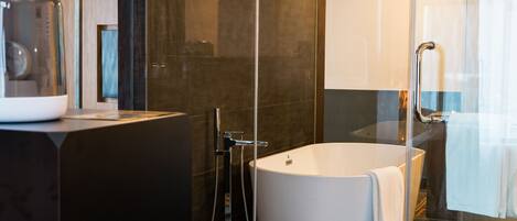 A modern bathroom with a freestanding bathtub, a glass shower enclosure, and a vanity with a mirror.
