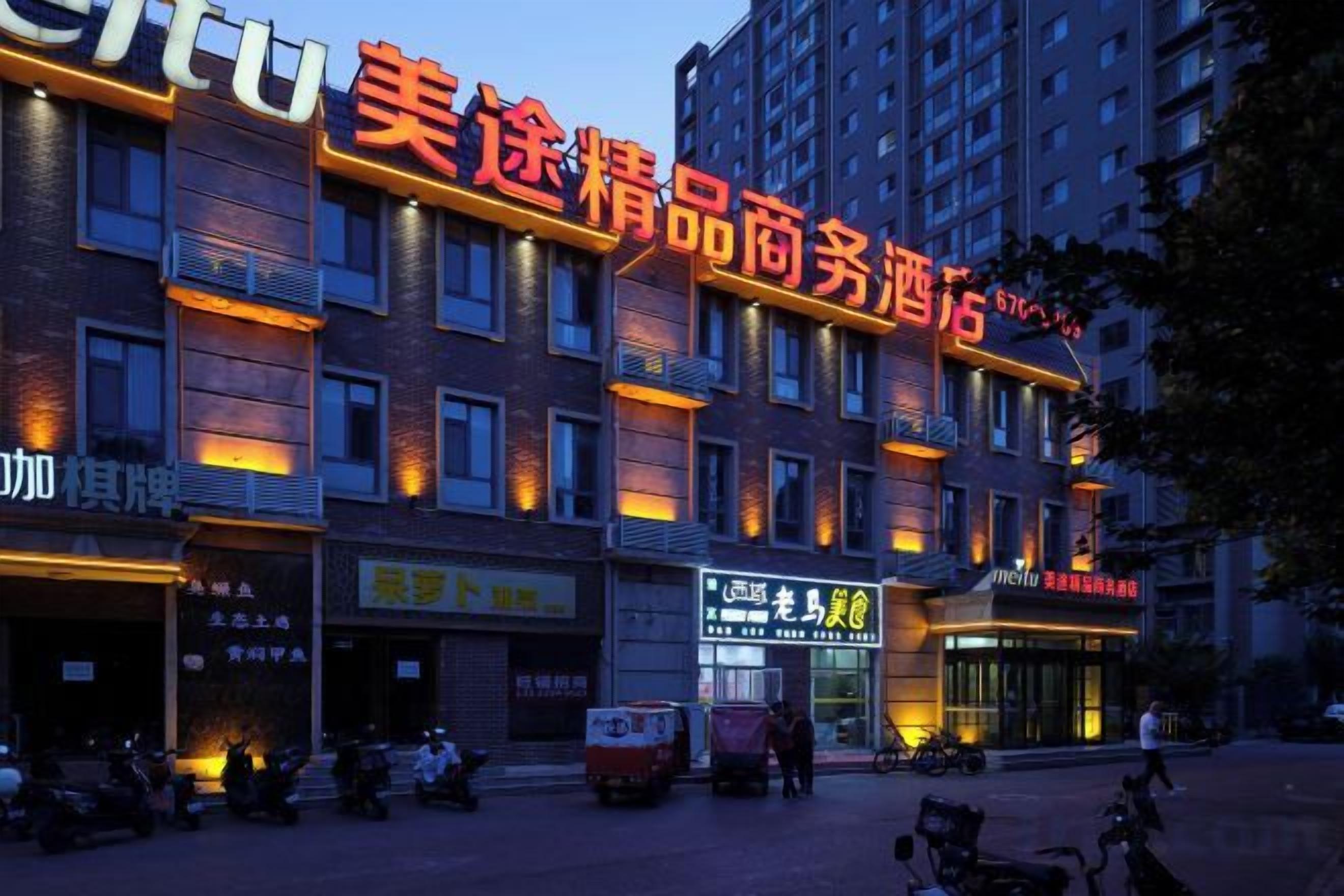Un hôtel à étages, une enseigne bien visible avec des caractères chinois, et plusieurs boutiques situées au rez-de-chaussée.