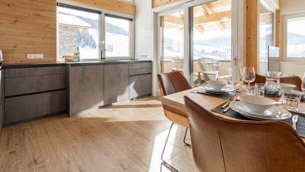 Une cuisine moderne avec un plafond en bois et de grandes fenêtres.