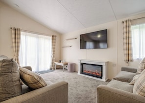 A living room with a fireplace, a flat-screen TV, and a sofa.