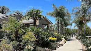 A residential area with a house, palm trees, and a pathway. - Villa 5B/3B with pool/spa/mini golf putting (Temecula)