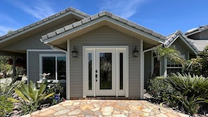 A house with a stone-paved entrance, a grey exterior, and a gabled roof. - Villa 5B/3B with pool/spa/mini golf putting (Temecula)