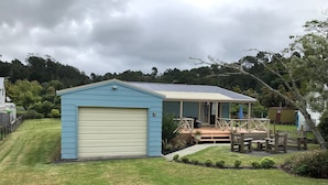 A blue single-story house with a covered porch and a garage.