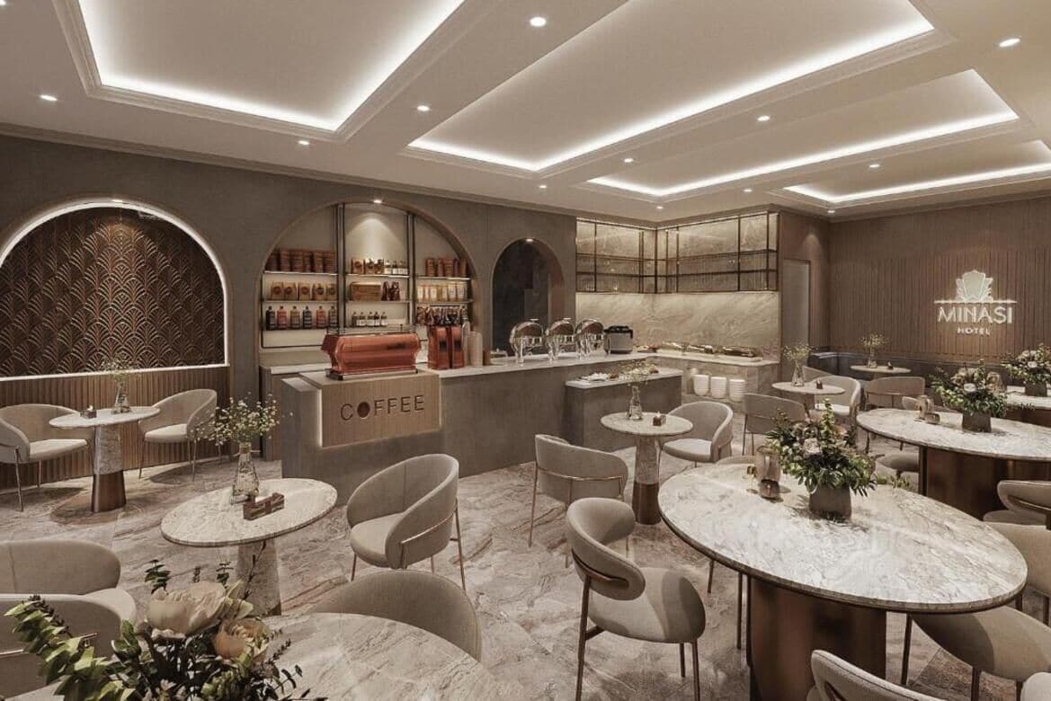 A modern hotel lobby with a coffee bar, seating areas, and a reception desk.