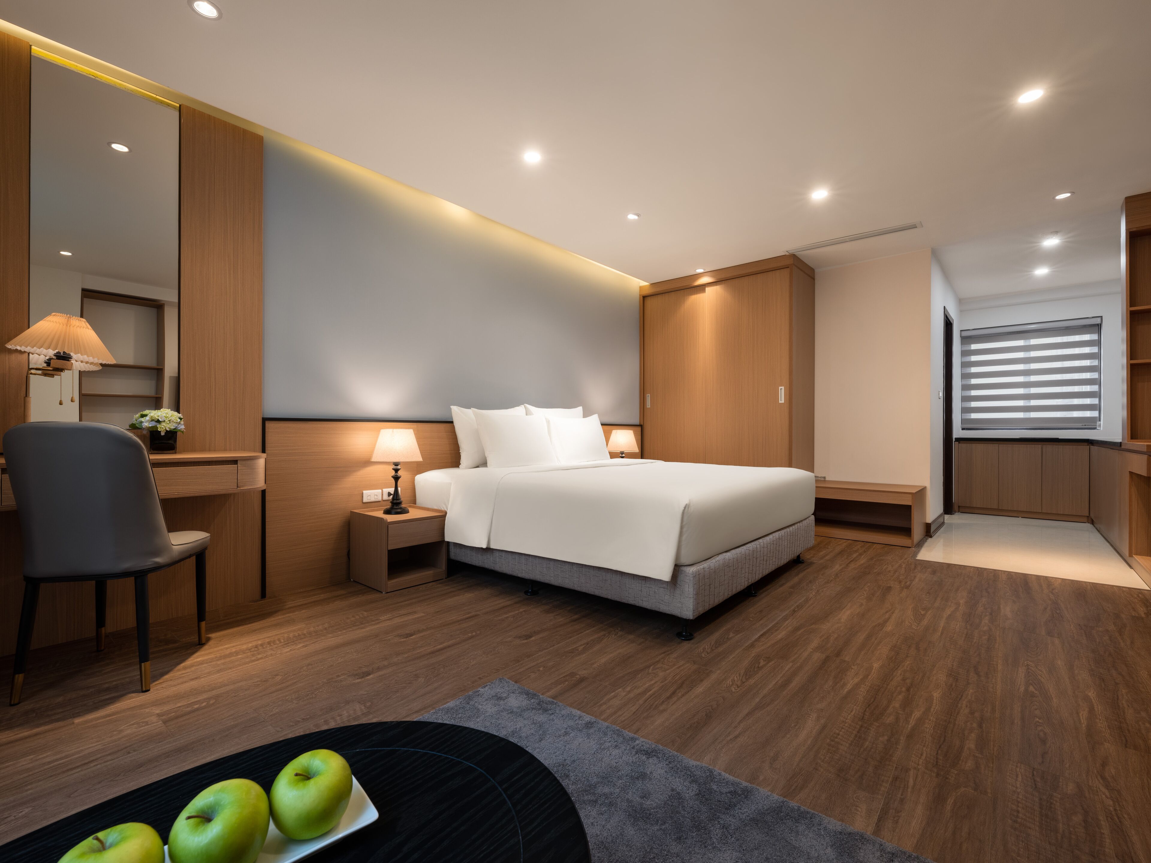 Une chambre d’hôtel moderne équipée d’un lit, de tables de chevet, d’un bureau et d’une chaise.