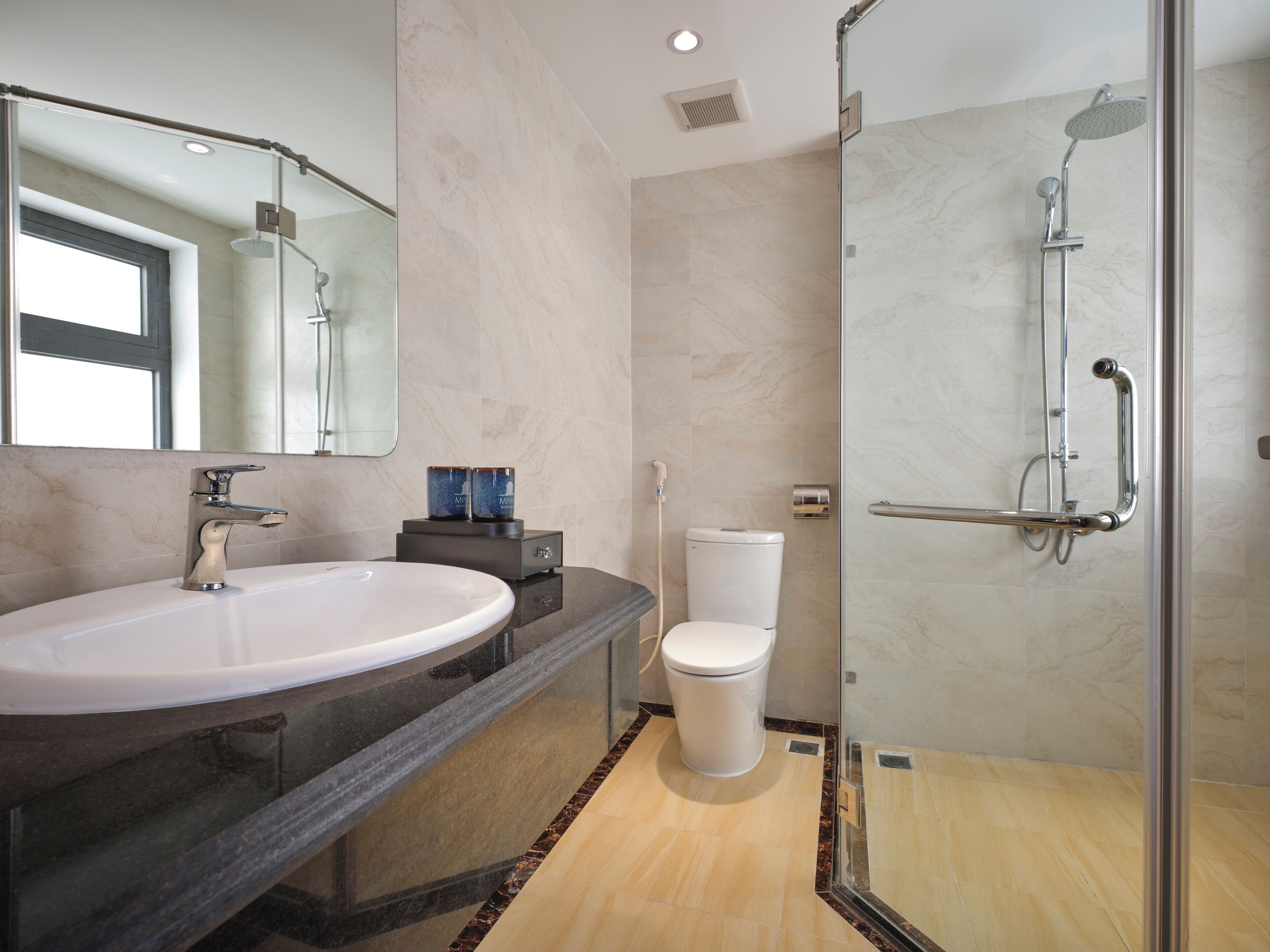 A modern bathroom with a large sink, toilet, and glass-enclosed shower.