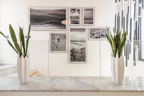 A wall with framed photographs and two potted plants. - Villa Panorama (Crikvenica)