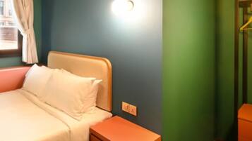 Un dormitorio con cama, mesita de noche y una lámpara de pared.