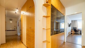 Un intérieur moderne avec des meubles en bois, une cloison en verre et un espace de bureau visible, comprenant un bureau et une chaise.