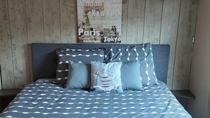 Ein ordentlich bezogenes Bett mit einer gemusterten Tagesdecke, Kissen und gefalteten Handtüchern.