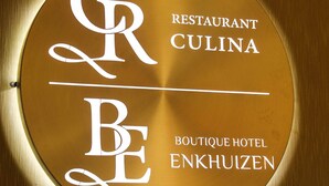 Una señal circular con la inscripción 'GR BE' y 'RESTAURANT CULINA', que indica un restaurante llamado Culinia en el Boutique Hotel Enkhuiten.