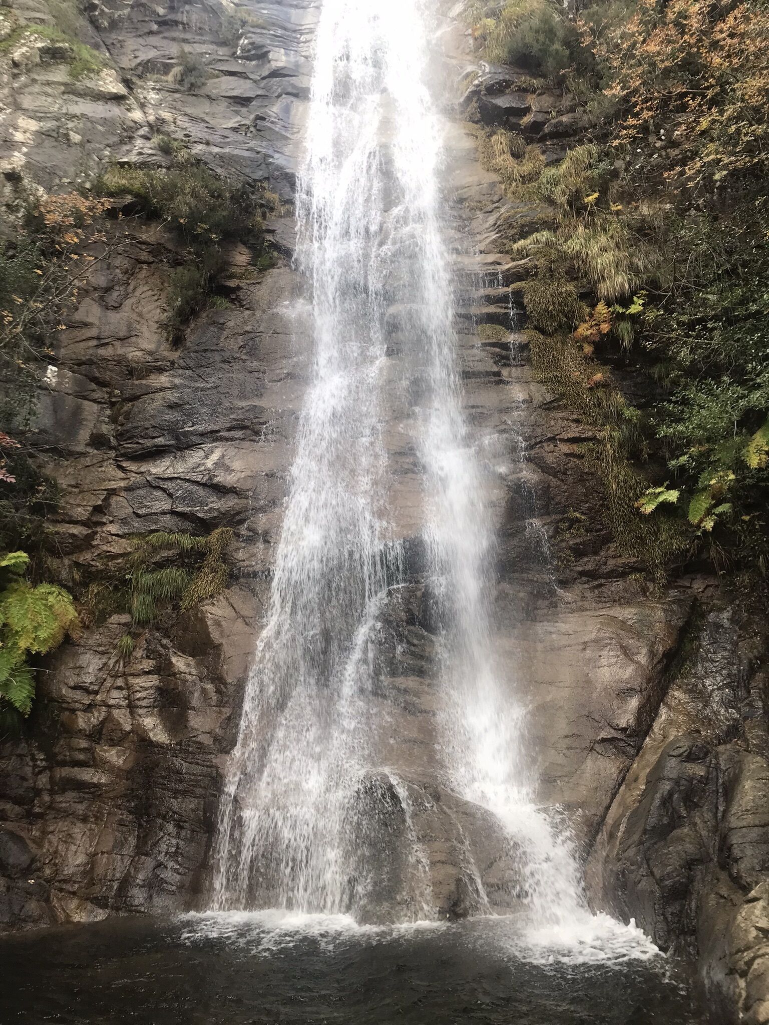 Ein Wasserfall stürzt über eine felsige Klippe.