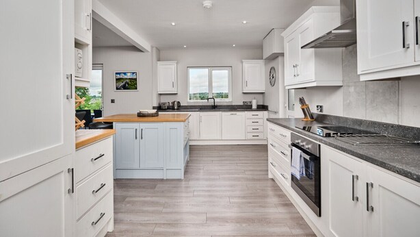 A modern kitchen with white cabinetry, a wooden countertop, and a built-in oven. - 12b Crest Rd · Escape Ordinary in Enniskillen (Enniskillen)