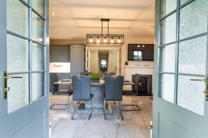 Une cuisine moderne dotée d’un îlot central, de tabourets de bar et d’une cheminée.