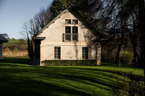 A house with a gabled roof, a balcony, and a well-maintained lawn.