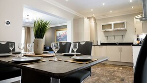 A dining area with a table set for four, a potted plant, and a painting on the wall. - LE 23 · Escape Ordinary at Castle Hume No.23 ~ Luxury (Fermanagh and Omagh)