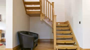 A staircase with wooden steps and a handrail, leading to an upper floor.