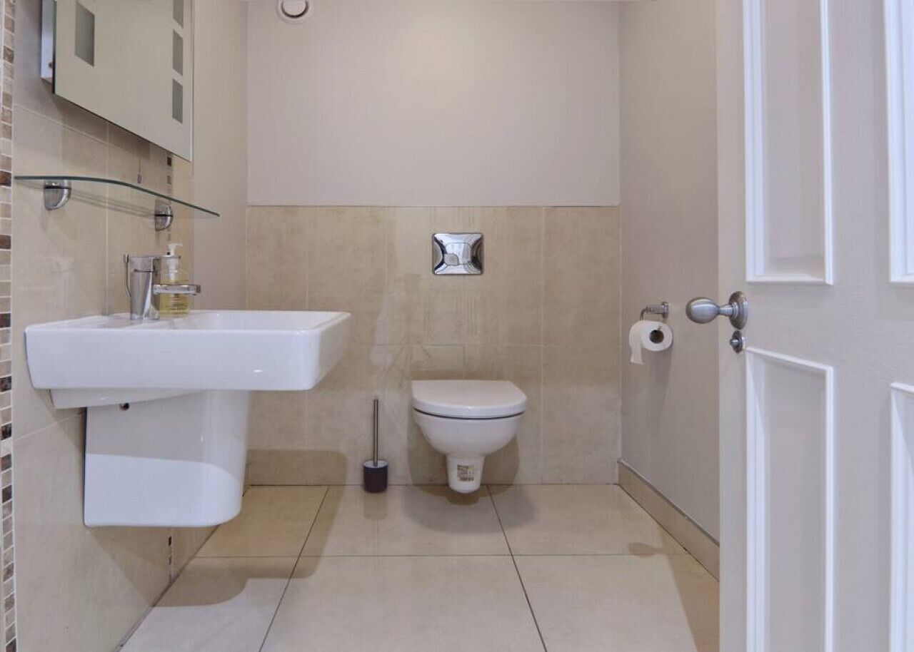 Ein Badezimmer mit Waschbecken, Toilette und einer Duschkabine aus Glas.
