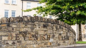 A stone wall with the inscription "DEVENISH WATERS" in large letters.