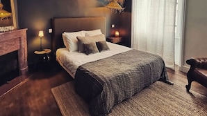 A modern bedroom with a large bed, a hanging light fixture, a nightstand with a lamp, and a view of the outdoors through a window. - Maison de Ville à Proximité du Port et des Commerces! (Camaret-sur-Mer)