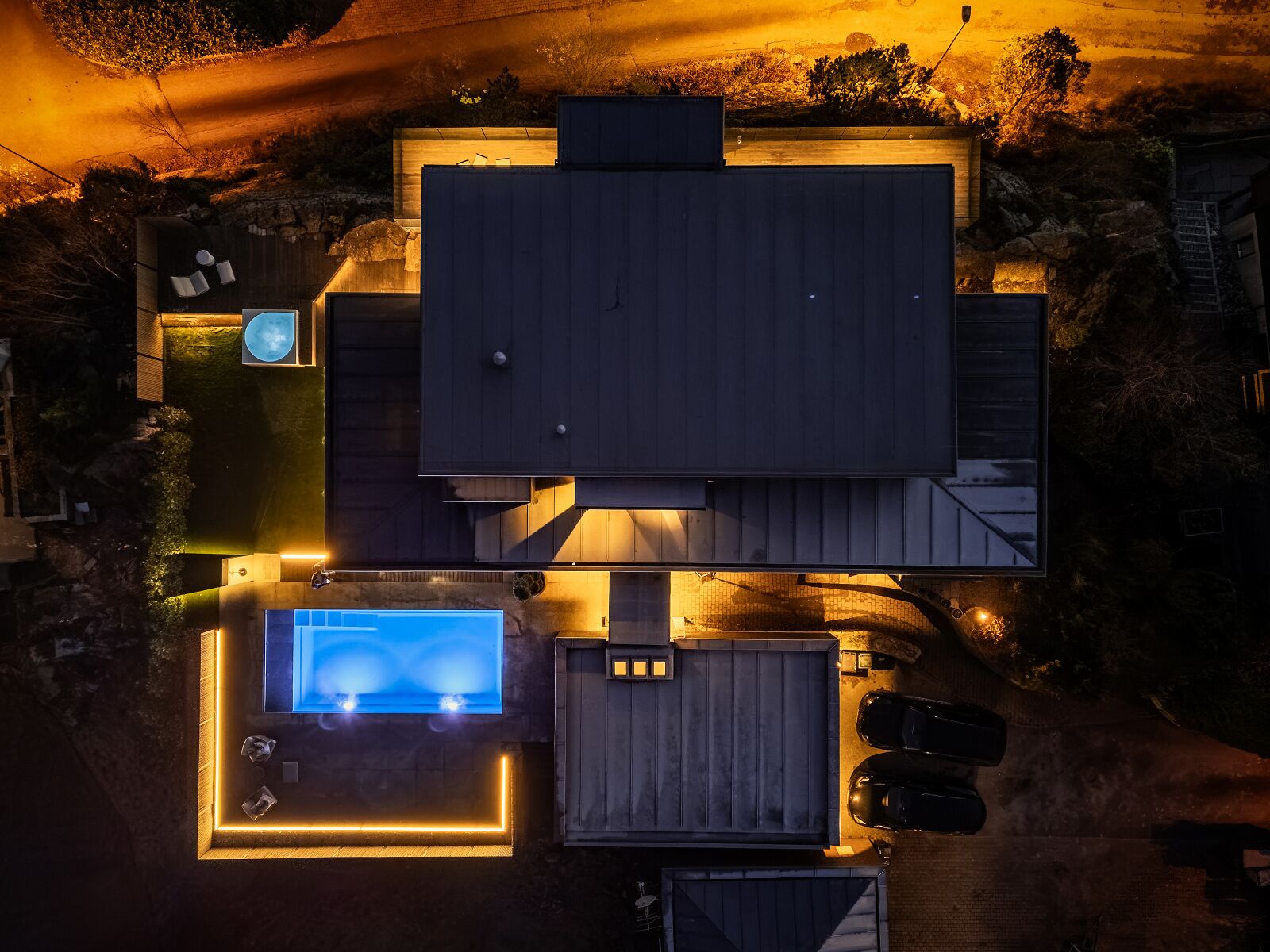 Vue aérienne d’une propriété résidentielle comprenant une grande maison, une piscine et un garage.