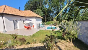 A house with a tiled roof, a swimming pool, and a patio with outdoor furniture. - Maison Neuve Bord de Dordogne (Lanzac)
