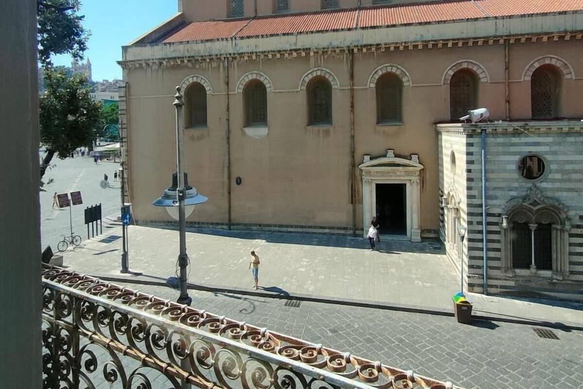 A building with a large arched entrance, a clock tower, and a tiled roof.