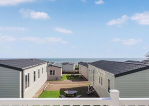 Eine Reihe von Mobilheimen mit einer Terrasse und Blick auf das Meer.