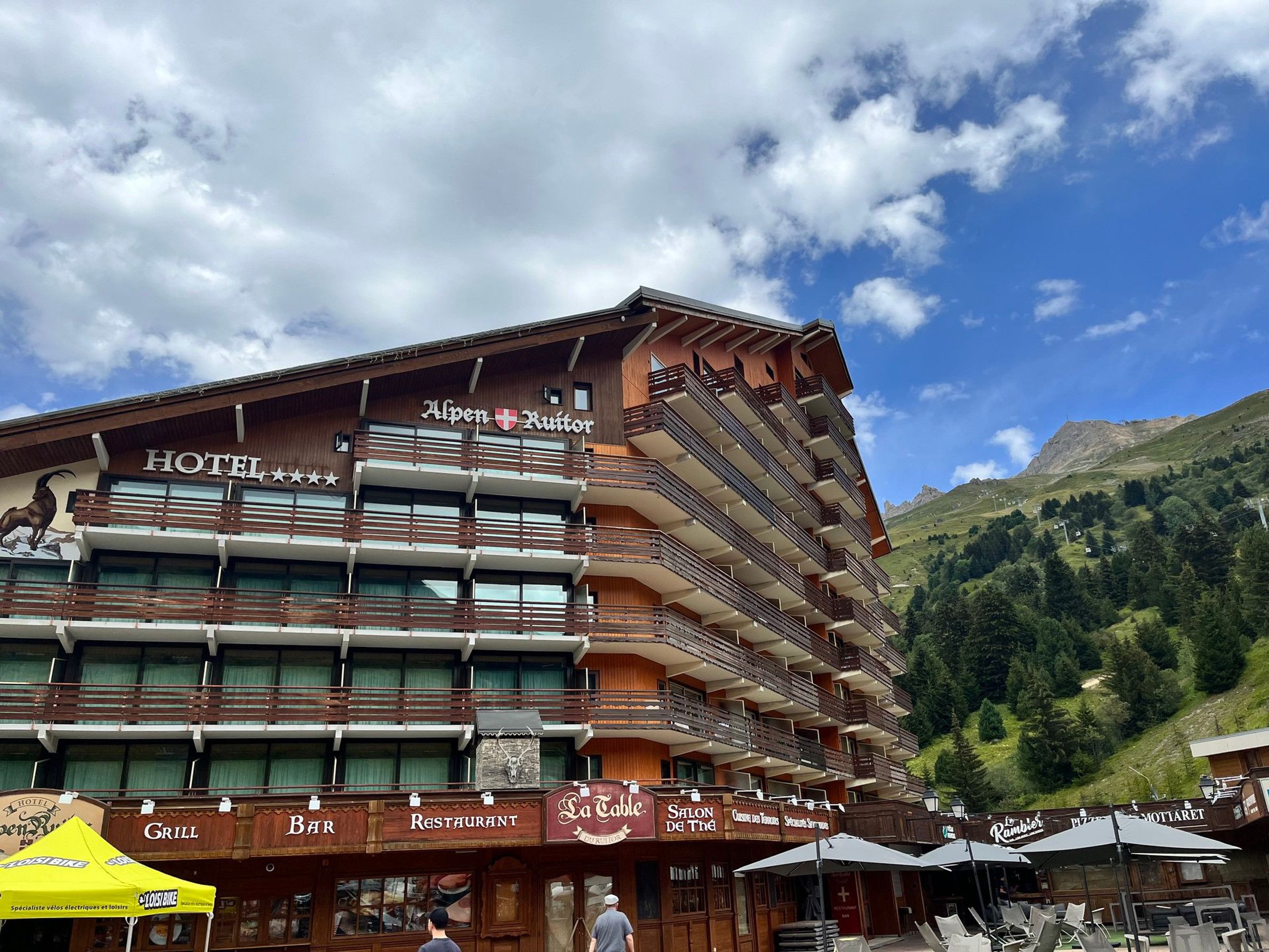 A hotel with multiple balconies, a restaurant, and a grill.