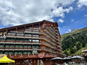 A hotel with multiple balconies, a restaurant, and a grill. - Spacious ski-in studio, Wi-Fi, Méribel (Méribel)