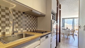 Una cocina moderna con un salpicadero a cuadros, un lavamanos de acero inoxidable y una encimera de madera.
