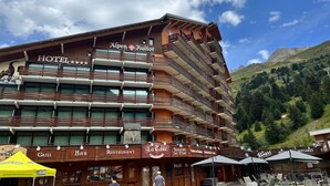 Un hotel con varios balcones, un restaurante y una parrilla.