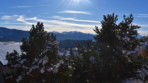 A clear view of a mountain range with snow-covered peaks and a bright sun in the sky. - Beautiful sunny 2-room apartment (Font-Romeu-Odeillo-Via)