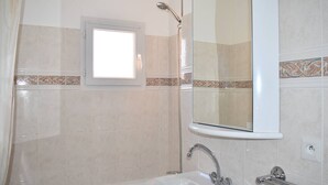 A bathroom with a bathtub, a sink, a shower, and a window. - Beautiful sunny 2-room apartment (Font-Romeu-Odeillo-Via)