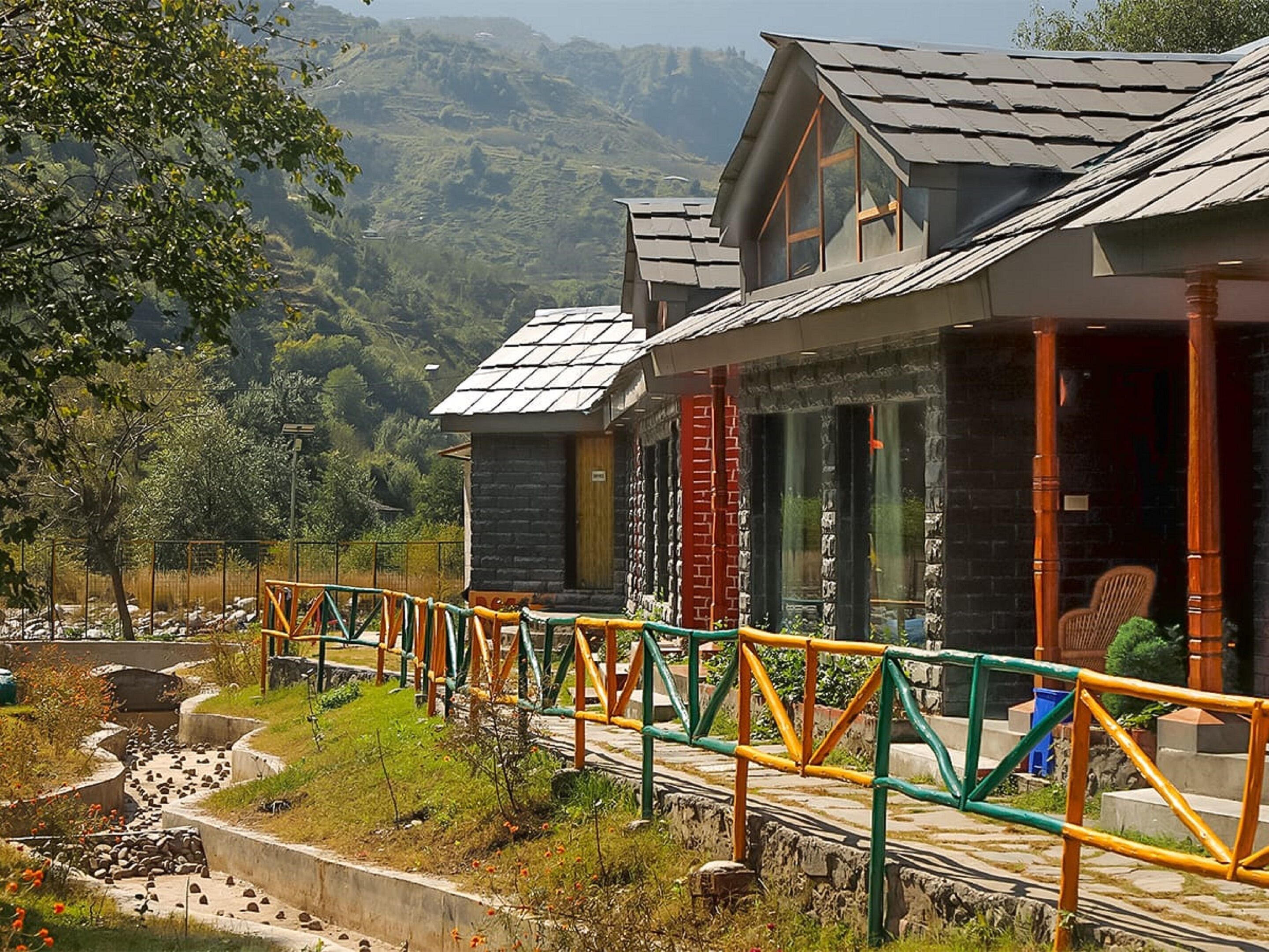 A hotel with a modern design, featuring a prominent glass facade and a sloped roof.