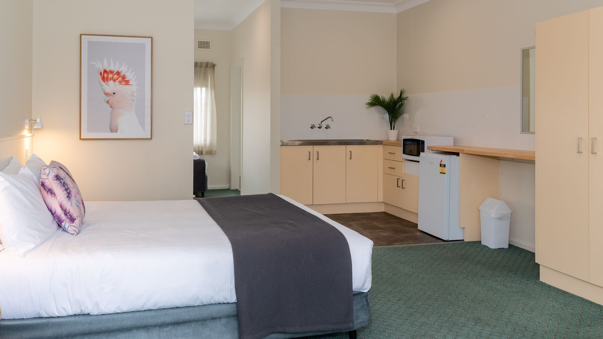 Ett hotellrum med en säng, ett litet pentry och ett badrum.