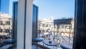 Ein Balkon mit Blick auf Gebäude, einem Tisch und zwei Stühlen.
