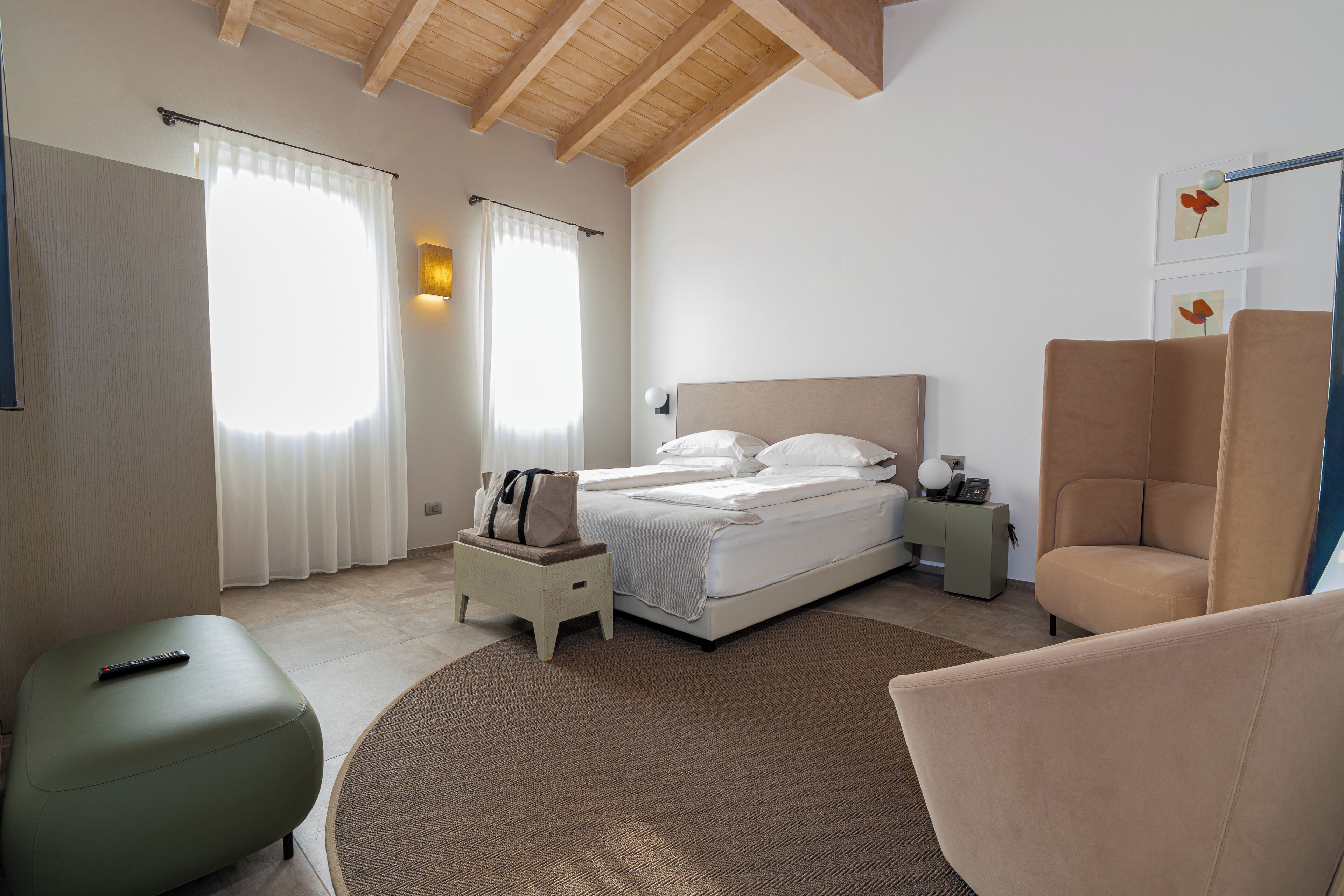 A bedroom with a bed, a nightstand, a chair, and a small table.