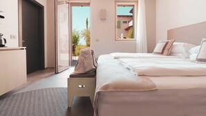 Una habitación de hotel moderna con una cama grande, un escritorio y vistas al exterior.
