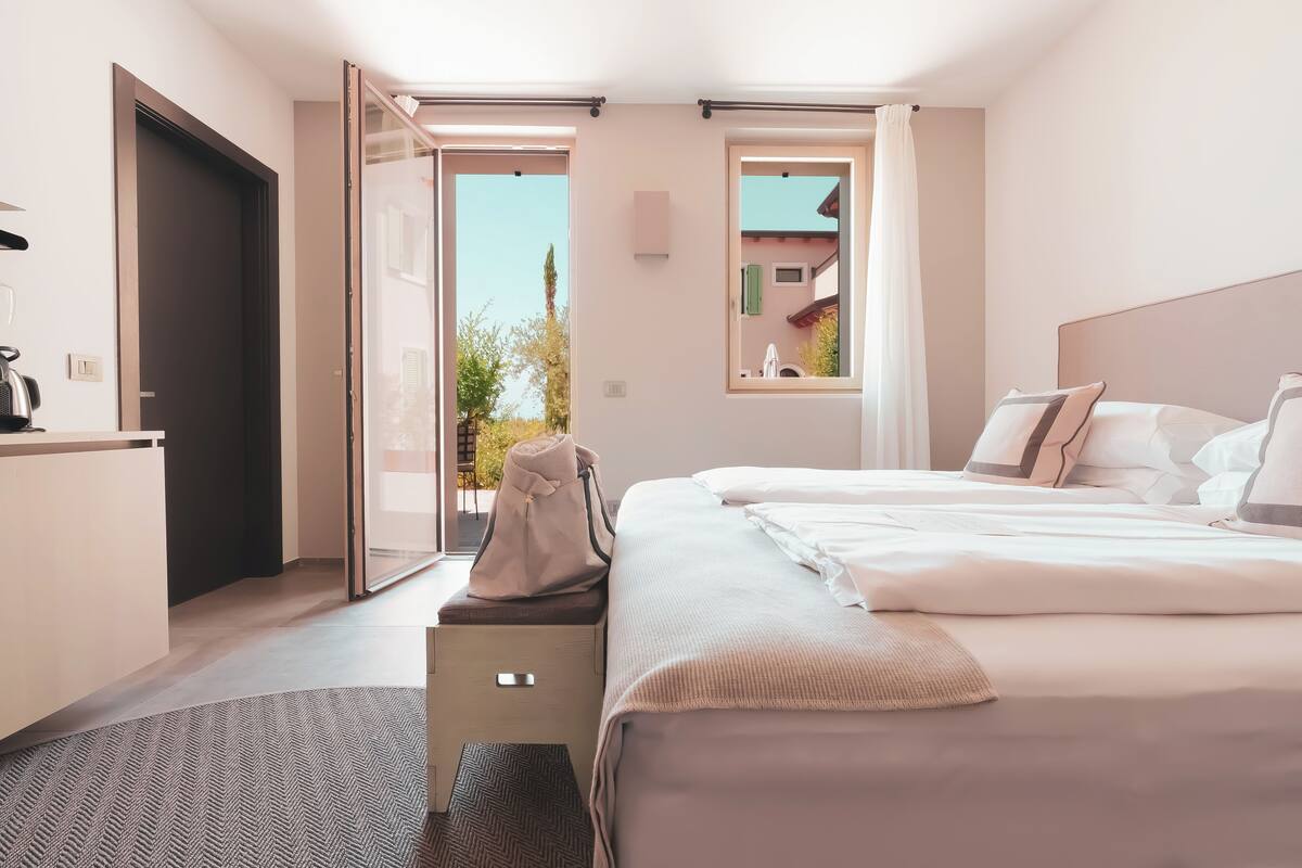 Ein modernes Hotelzimmer mit einem großen Bett, einem Schreibtisch und Blick ins Freie.