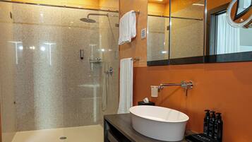 Un baño moderno con ducha de vidrio, una bañera independiente y un tocador con un espejo grande.