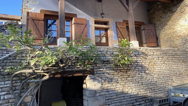 Un bâtiment rustique aux murs de pierre, aux poutres en bois et au toit en pente.