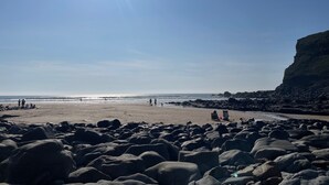 A rocky beach with people and a clear sky. - Millers cottage, a picturesque semi detached cottage with private garden (Woolfardisworthy)