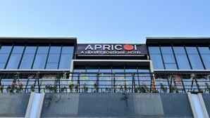 A building with a sign that reads "APRICOT A LUXURY BOUTIQUE HOTEL". - Apricot Motera  (Ahmedabad)