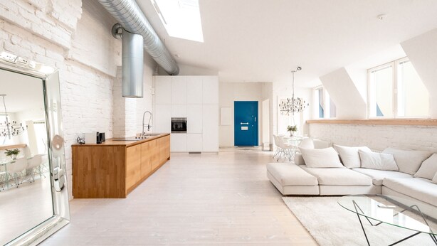 A modern kitchen with white cabinets, a wooden island, and a blue door in the background. - 2ndhomes Luminous 2BR Loft House w Sauna (Helsinki)